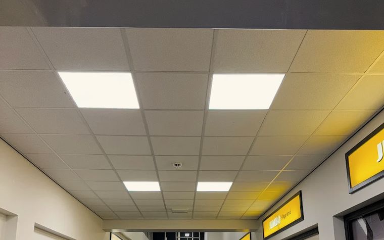 LED-verlichtingspanelen in het verlaagde plafond van een winkelpassage.
